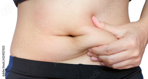 woman hand catching fat body belly paunch isolated on white background, diabetic risk factor .
