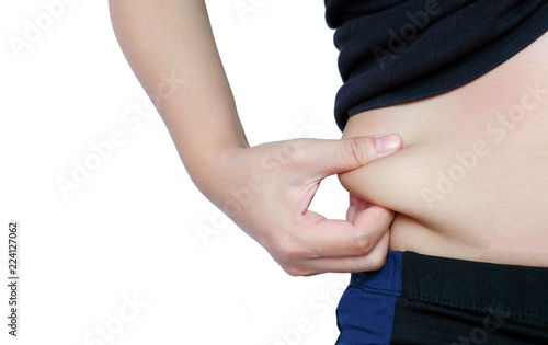 woman hand catching fat body belly paunch isolated on white background, diabetic risk factor . photo