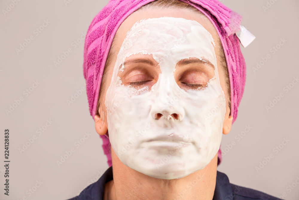 girl with facial mask looking at camera over white background. Cosmetic procedure. Beauty spa and cosmetology. girl with facial mask looking at camera over white background. Cosmetic procedure. Beauty spa and cosmetology.