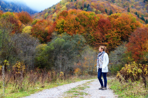 Beautiful young woman hikes in the forest in the mountains of the Rila Nature Park in Bulgaria with vibrant autumn colors © dennisvdwater