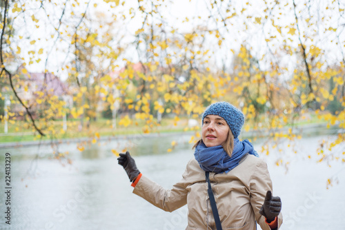 Cheerful woman is walking in the park in autumn