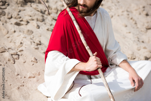 фотографія cropped image of Jesus in robe, red sash and crown of thorns sitting in lotus po