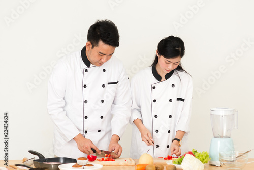 Asian chef man teaching his cook helper preparing food, work lifestyle concept.