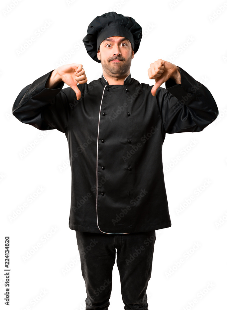 Chef man In black uniform showing thumb down with both hands. Negative expression on isolated white background Chef man In black uniform showing thumb down with both hands. Negative expression on isolated white background