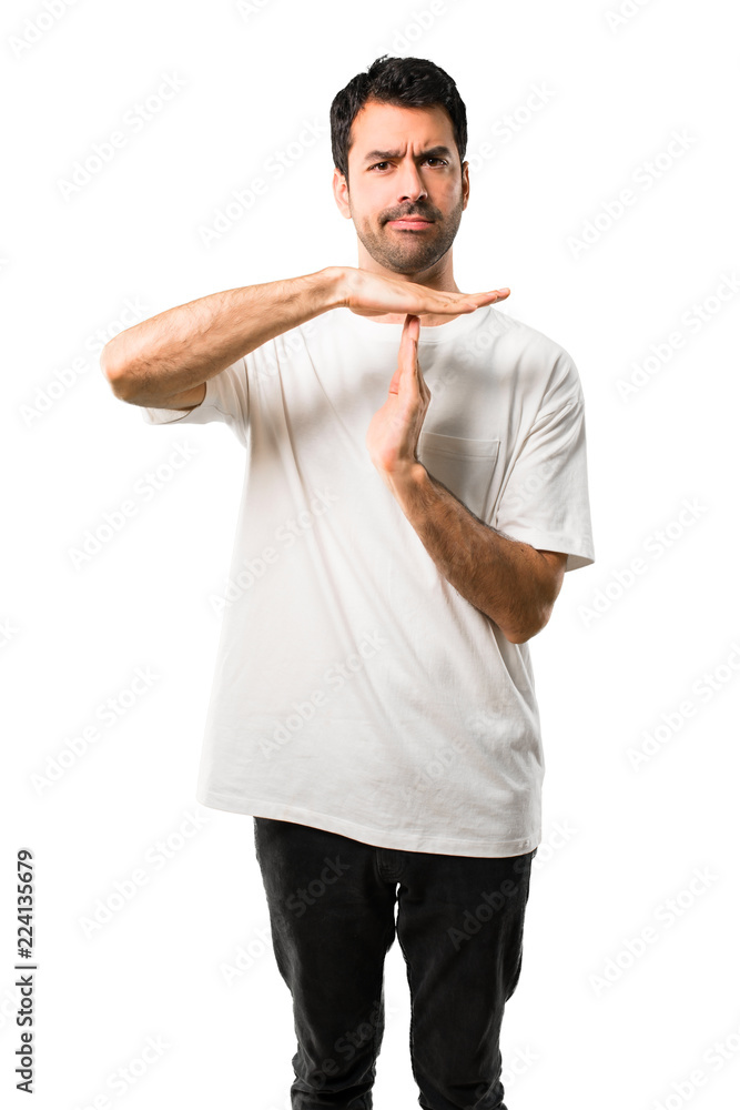 Young man with white shirt making stop gesture with her hand to stop an act on isolated white background Young man with white shirt making stop gesture with her hand to stop an act on isolated white background