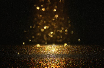 glitter vintage lights background. black and gold. de-focused.