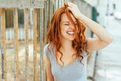 Woman with hair and grey shirt pulling her hair photo