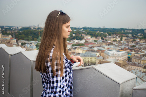 Tourist girl on top of european city hall with dramatic sky