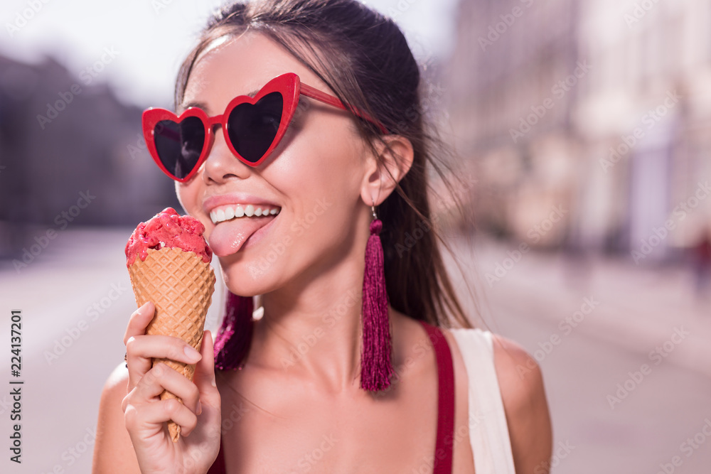 Amazing taste. Nice happy woman smiling while trying the cherry ice cream Amazing taste. Nice happy woman smiling while trying the cherry ice cream