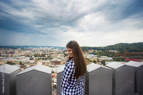 Tourist girl on top of european city hall with dramatic sky
