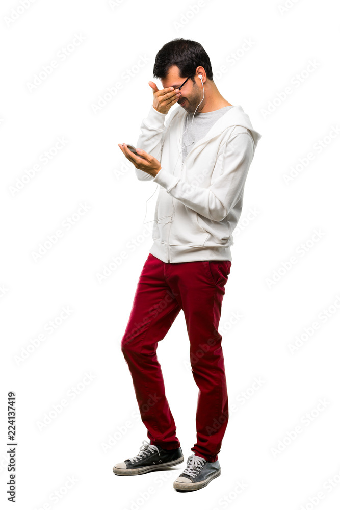 A full-length shot of a Man with glasses and listening music covering eyes by hands. Surprised to see what is ahead on white background A full-length shot of a Man with glasses and listening music covering eyes by hands. Surprised to see what is ahead on white background