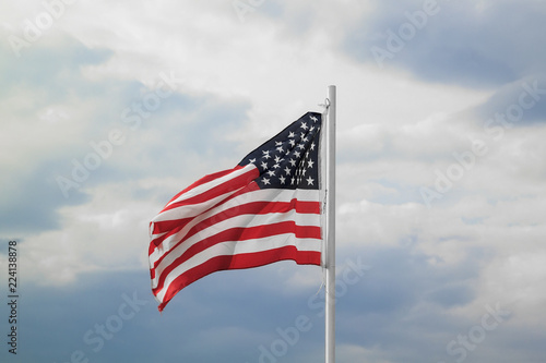 American flag on a blue sky with clouds background
