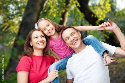 Happy smiling family with daughter over green