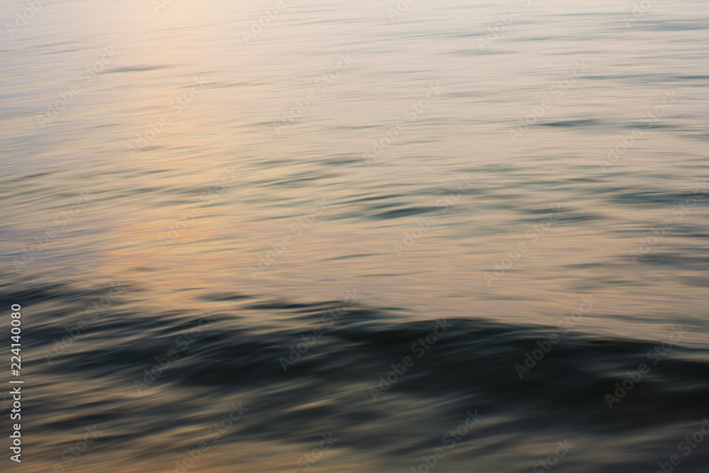 Detail of waves building on water, and a ridge of water approaching the beach at sunset. Detail of waves building on water, and a ridge of water approaching the beach at sunset.