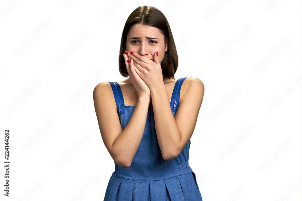 Girl crying with hands covering mouth. Young afraid woman crying over white background. Illness, problems, pain. Girl crying with hands covering mouth. Young afraid woman crying over white background. Illness, problems, pain.