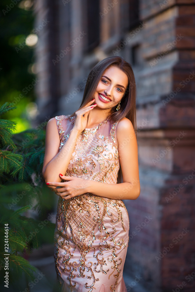 Portrait of elegant young woman with long hair and perfect smile on old building background Portrait of elegant young woman with long hair and perfect smile on old building background