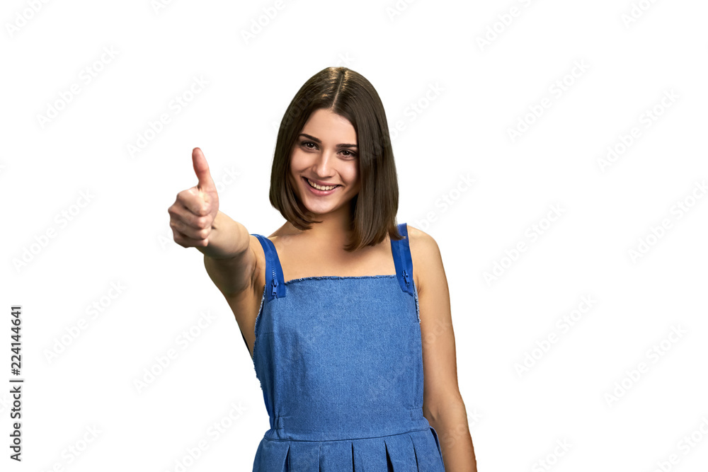 Young cheerful brunette with thumb up sign. Portrait of happy teenage girl giving thumb up isolated on white background. Young cheerful brunette with thumb up sign. Portrait of happy teenage girl giving thumb up isolated on white background.