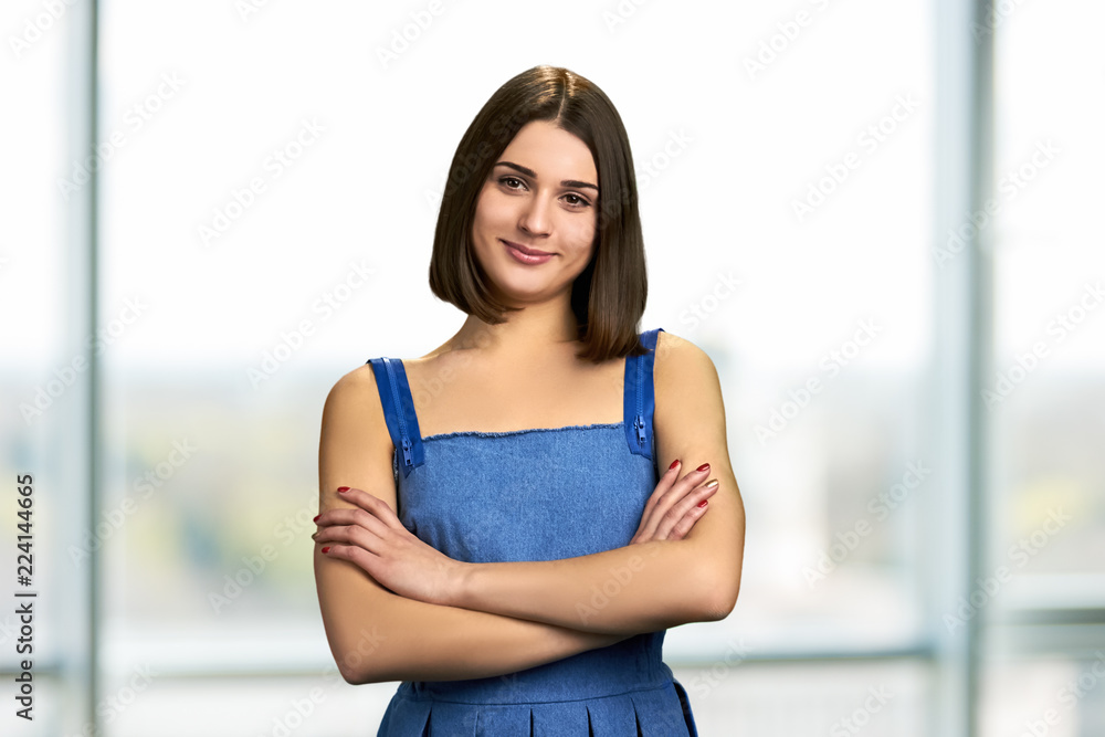 Pretty student with arms crossed. Cute cheerful girl standing with folded arms. Attractive smiling female.