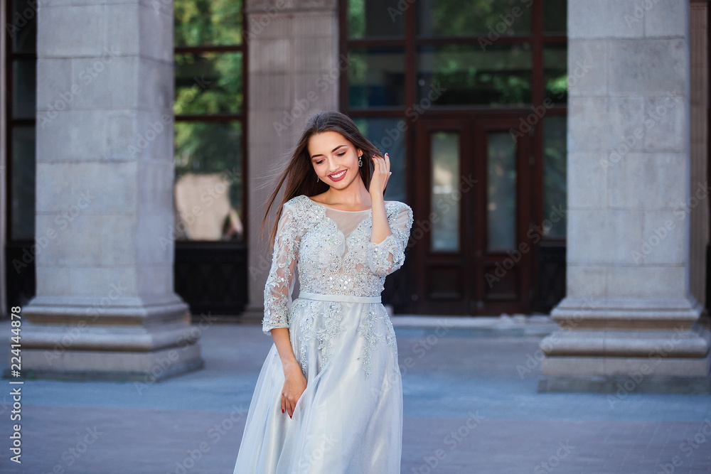 Portrait of elegant young woman with long hair and perfect smile on old building background Portrait of elegant young woman with long hair and perfect smile on old building background