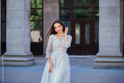 Portrait of elegant young woman with long hair and perfect smile on old building background © sergiophoto