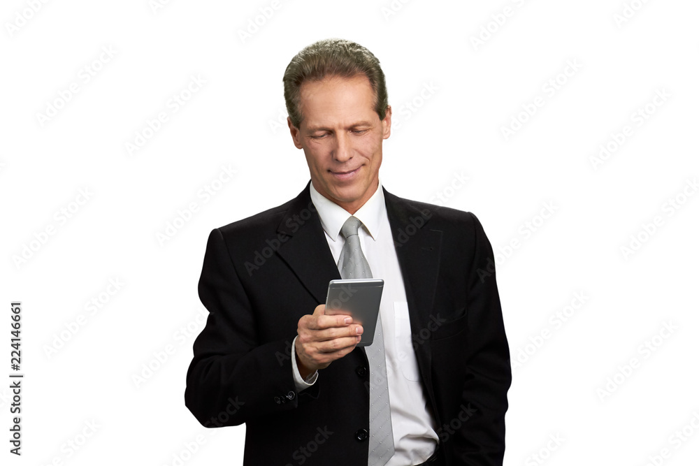 Man in business suit looking at smartphone. Portrait of mature caucasian businessman reading information on his smartphone, isolated on white background. Man in business suit looking at smartphone. Portrait of mature caucasian businessman reading information on his smartphone, isolated on white background.