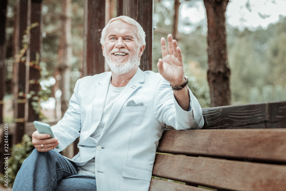 Here I am. Handsome bearded male person keeping smile on his face while looking forward Here I am. Handsome bearded male person keeping smile on his face while looking forward