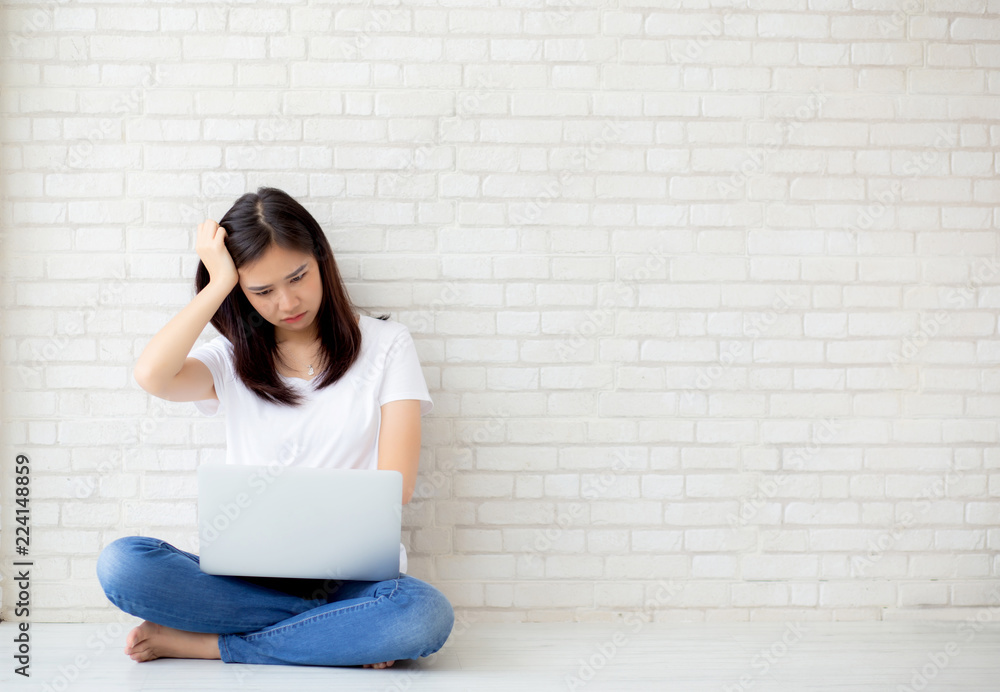 Beautiful of portrait asian young woman working online laptop and thinking and serious sitting on floor brick cement background, freelance girl using notebook computer, business and lifestyle concept. Beautiful of portrait asian young woman working online laptop and thinking and serious sitting on floor brick cement background, freelance girl using notebook computer, business and lifestyle concept.