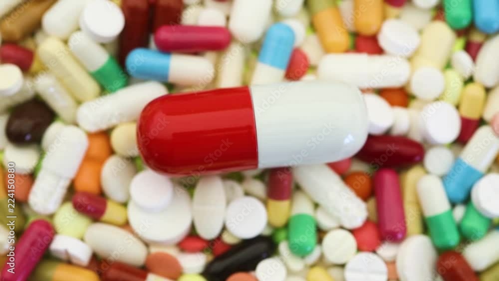 Closeup shot of spinning pills with large pill in center Closeup shot of spinning pills with large pill in center