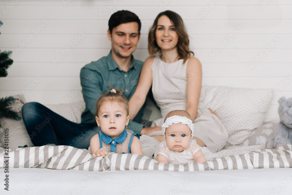 Happy parents with baby in decorated room for Christmas