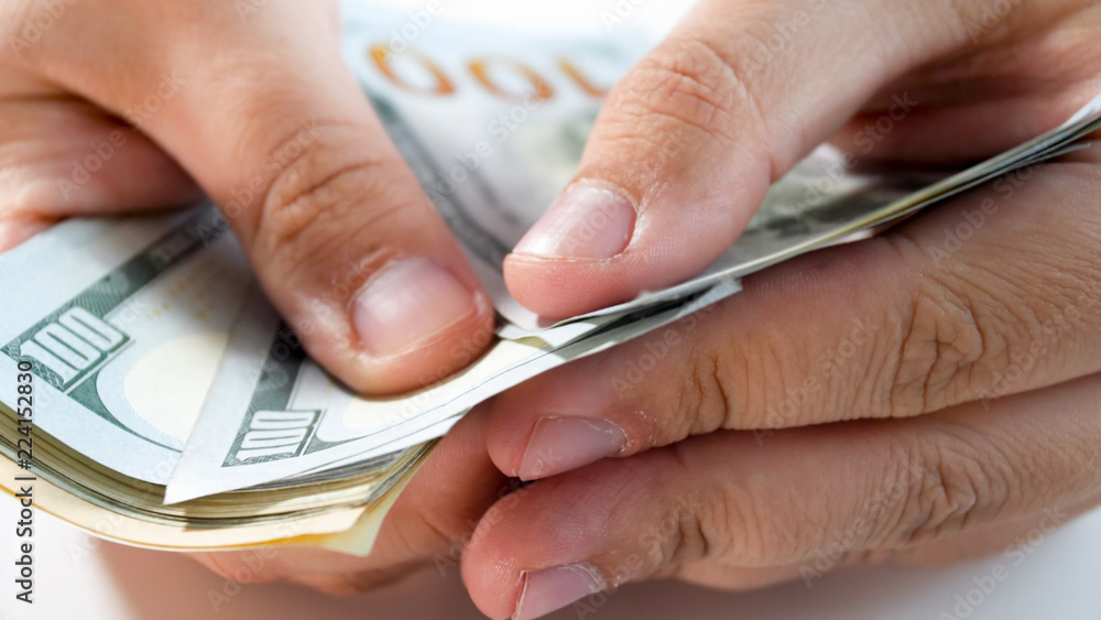 Closeup image of man holding and counting stack of money Closeup image of man holding and counting stack of money