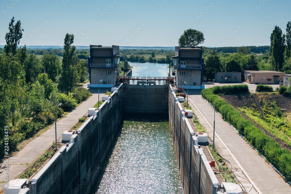Gateway lock sluice construction on river dam for passing ships and boats 