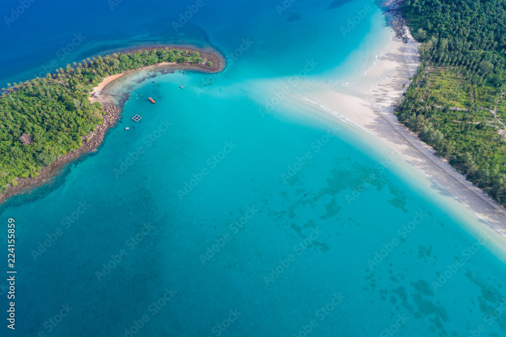 Aerial view of exotic turquoise sea with white beach green tree island