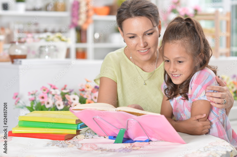 Obraz premium little girl with her mother doing homework