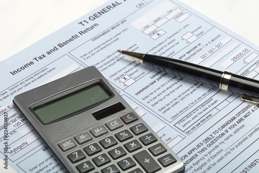 Calculator and pen on top of tax forms Calculator and pen on top of tax forms