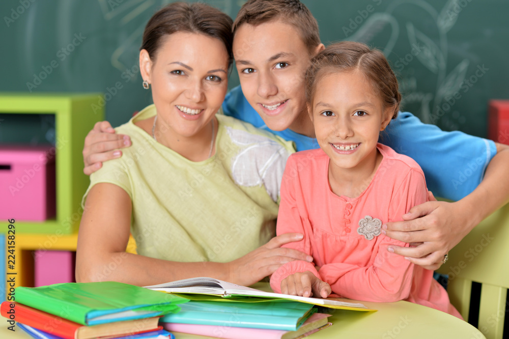 Portrait of mother with children doing homework Portrait of mother with children doing homework