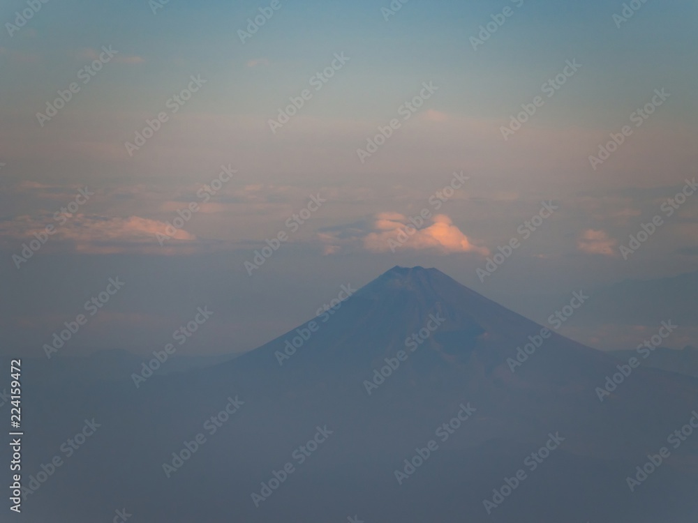 Mount Fuji in summer with cloudy sky and morning light. Aerial view from an airplane. - Max zoom version