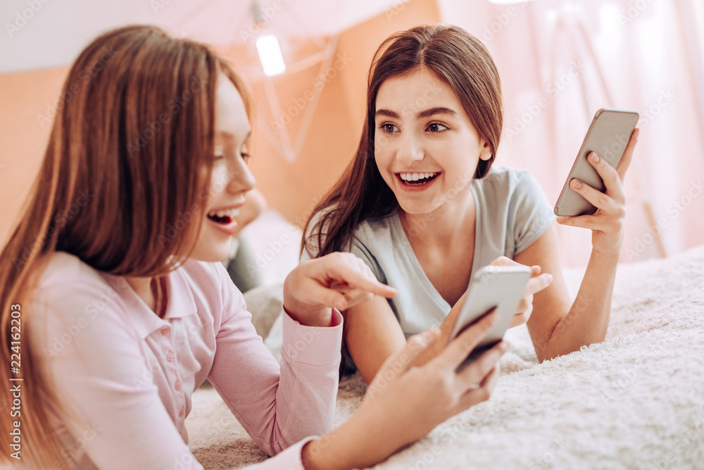 Best friends. Cheerful brunette girl keeping smile on her face and talking to her best friend Best friends. Cheerful brunette girl keeping smile on her face and talking to her best friend