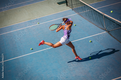 Female tennis player hits the ball with Forehand drive volley.
