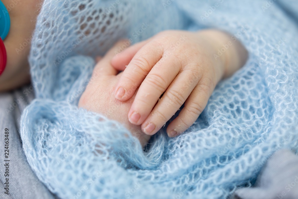 hands of a newborn baby. hands on blue . children's hands hands of a newborn baby. hands on blue . children's hands