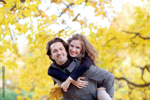 Smiling couple play in autumn forest