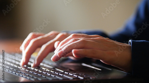 Women hands are printing on the laptop keyboard. Detail shot