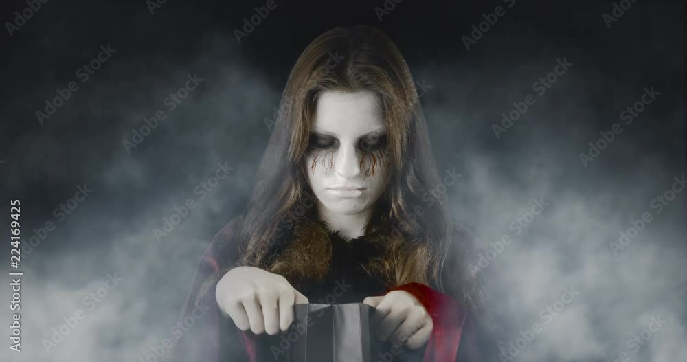 Checking the treats - teenage girl, disguised for Halloween, standing in an eerie, foggy environment - ProRes Checking the treats - teenage girl, disguised for Halloween, standing in an eerie, foggy environment - ProRes