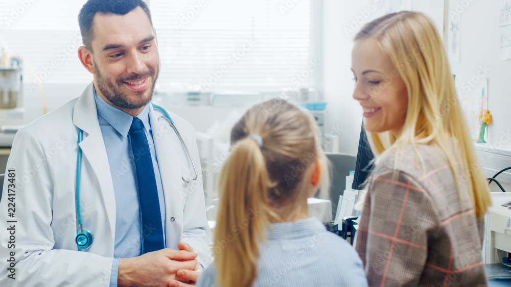 Friendly Doctor Does Routine Examination of a Sweet Little Girl who Came with Her Mother. Pediatrician Talks to Both of them. Doctor's Office is Bright and Modern. Friendly Doctor Does Routine Examination of a Sweet Little Girl who Came with Her Mother. Pediatrician Talks to Both of them. Doctor's Office is Bright and Modern.