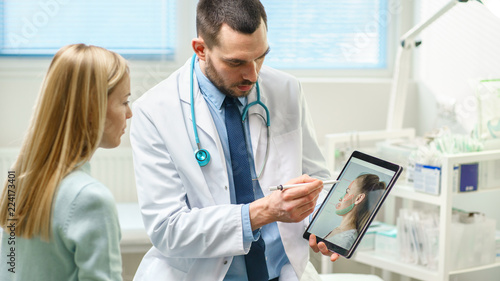 Konstfotografi Plastic / Cosmetic Surgeon Consults Woman about Facial Lift Surgery, He Draws Arrows on Digital Tablet Computer Screen, Showing Types of Facelift, Forehead Correcting Procedures Available for Her