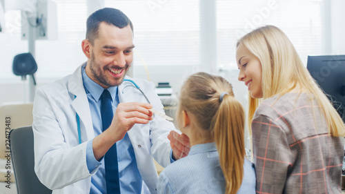 Friendly Doctor Checks up Little Girl's Sore Throat, Mother is Present for Support. Modern Medical Health Care, Friendly Pediatrician and Bright Office. © Gorodenkoff