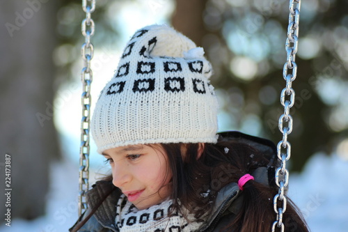 Bambina in altalena sulla neve photo