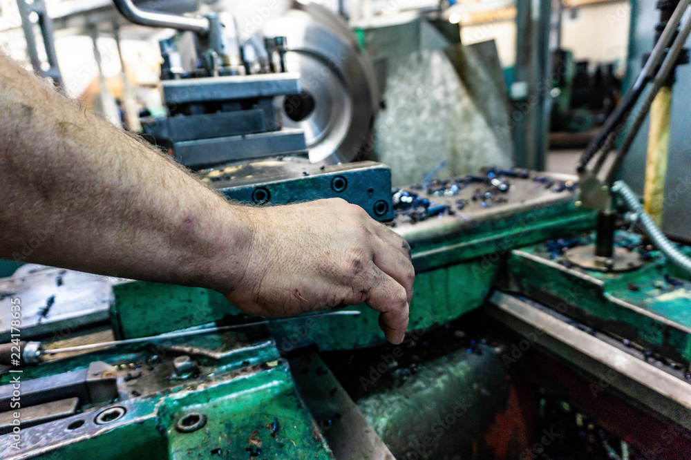 The worker, the man, makes mechanical actions of the machine control. Turning work in production. The worker, the man, makes mechanical actions of the machine control. Turning work in production.