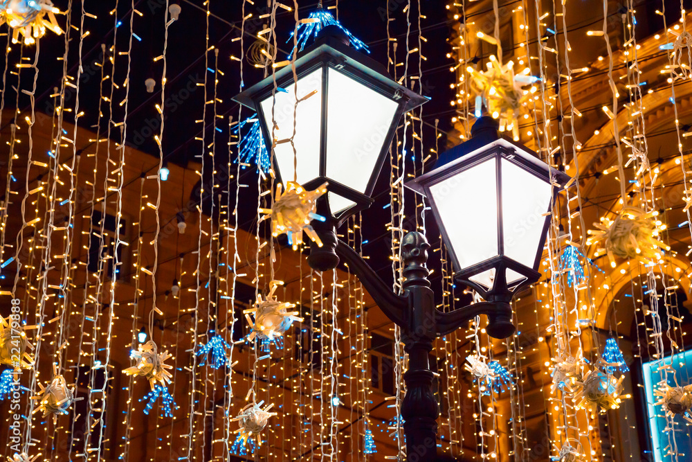 Street lights and Christmas decoration to New Year and holidays. Festive  background. Illumination and vintage lantern on Nikolskaya street in  Moscow, Russia. Winter night at city street. Stock Photo | Adobe Stock