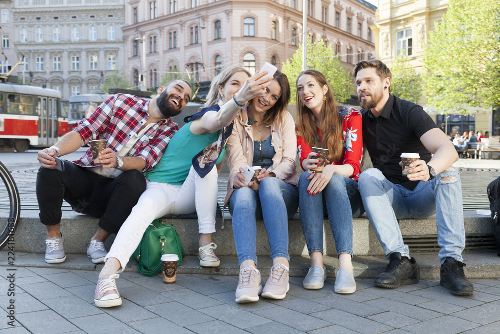best friends take a group selfie downtown and enjoy carefree lifestyle with coffee to go
