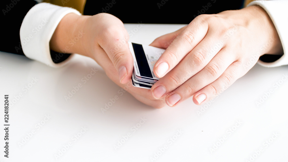 Closeup image of female hands holding stack of bank credit cards Closeup image of female hands holding stack of bank credit cards